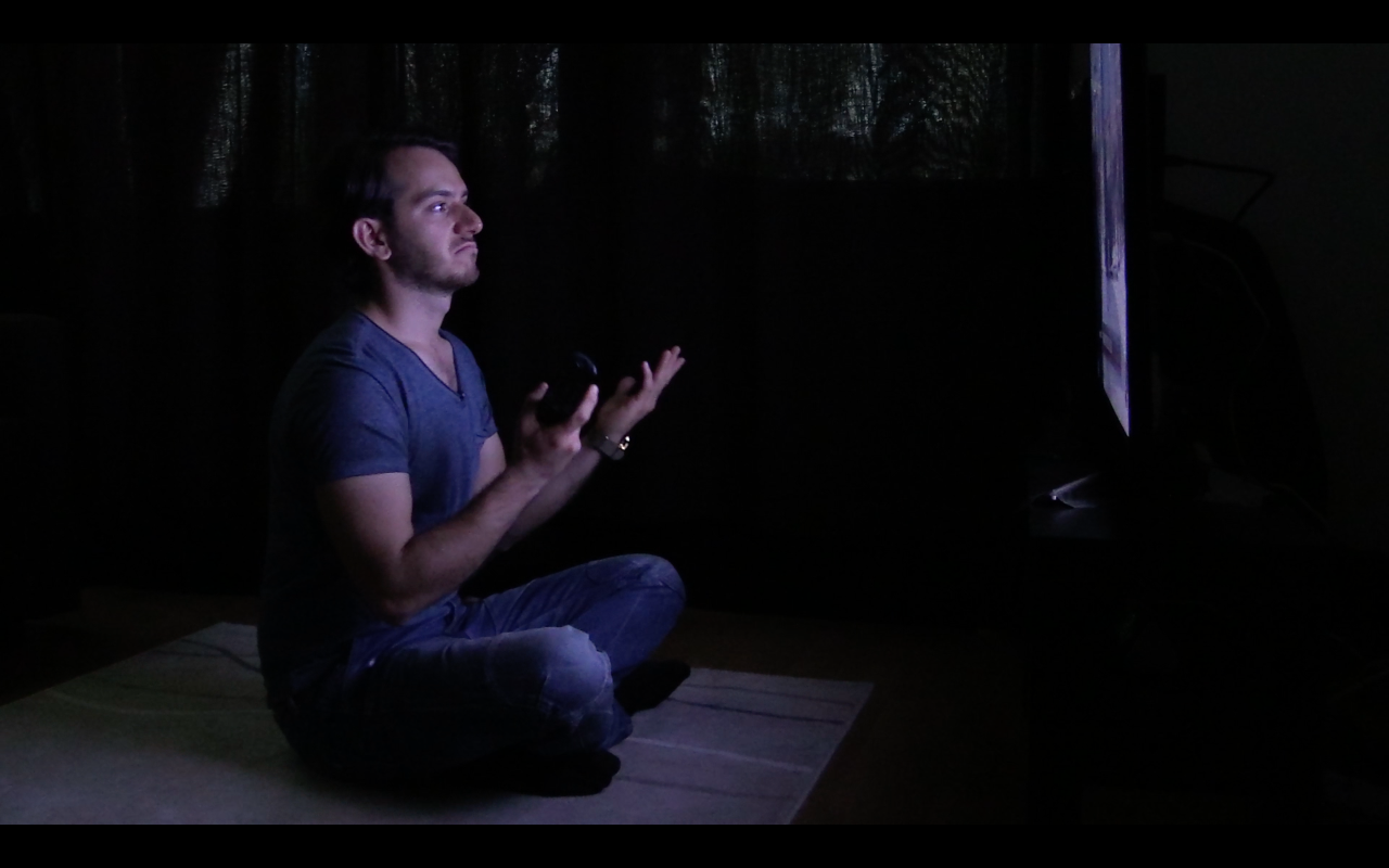 Man watching tv, making a gesture with his hands, looking unhappy
