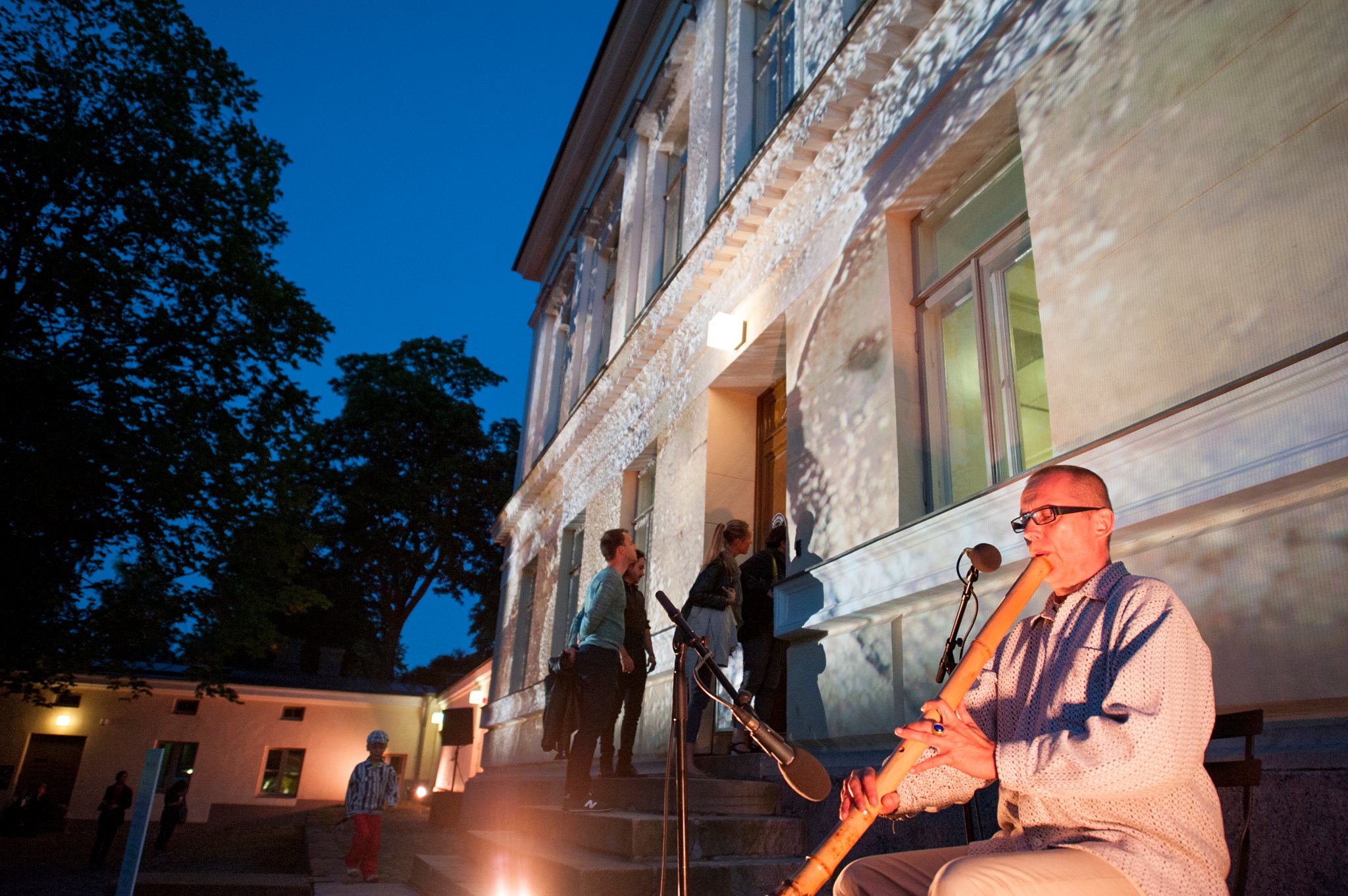 Tales from Frontiers Jone Takamäki playing music, projection on the background