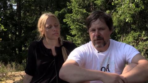 Tellervo and Oliver Kalleinen sitting in a summer landscape