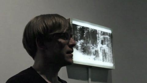 Tuomo Rainio with artwork in the background